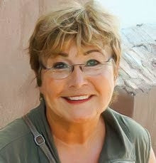 Bild von der lächelnden Dr. med. Hiltrud Förster. Sie trägt ein grünes Hemd und eine Brille. Im Hintergrund ist eine Wand.